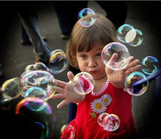 девочка ловит мыльные пузыри