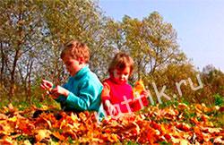 мальчик и девочка играют с листьями