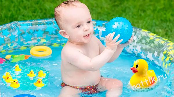 ребенок играет с мячом в бассейне